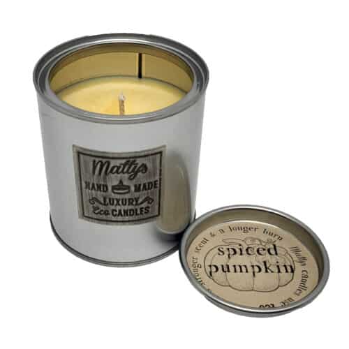 A metal tin labeled "Matty's Handmade Luxury Eco Candles" holds a yellow Spiced Pumpkin Scented Candle, with its lid beside it reading "SPICED PUMPKIN"—ideal for pumpkin spice scent fans.