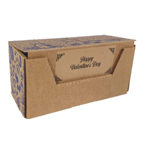 A brown cardboard box with an open front pocket displaying a card that reads “Happy Valentine’s Day.” The sides and top of the box have decorative blue designs.